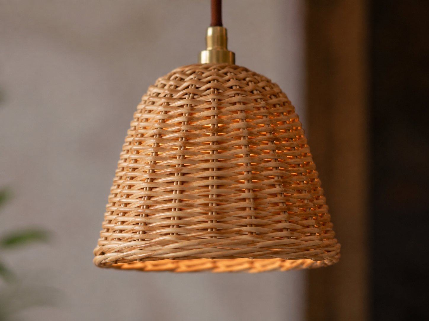 Small rattan pendant light hanging above a reading chair in a warm modern interior