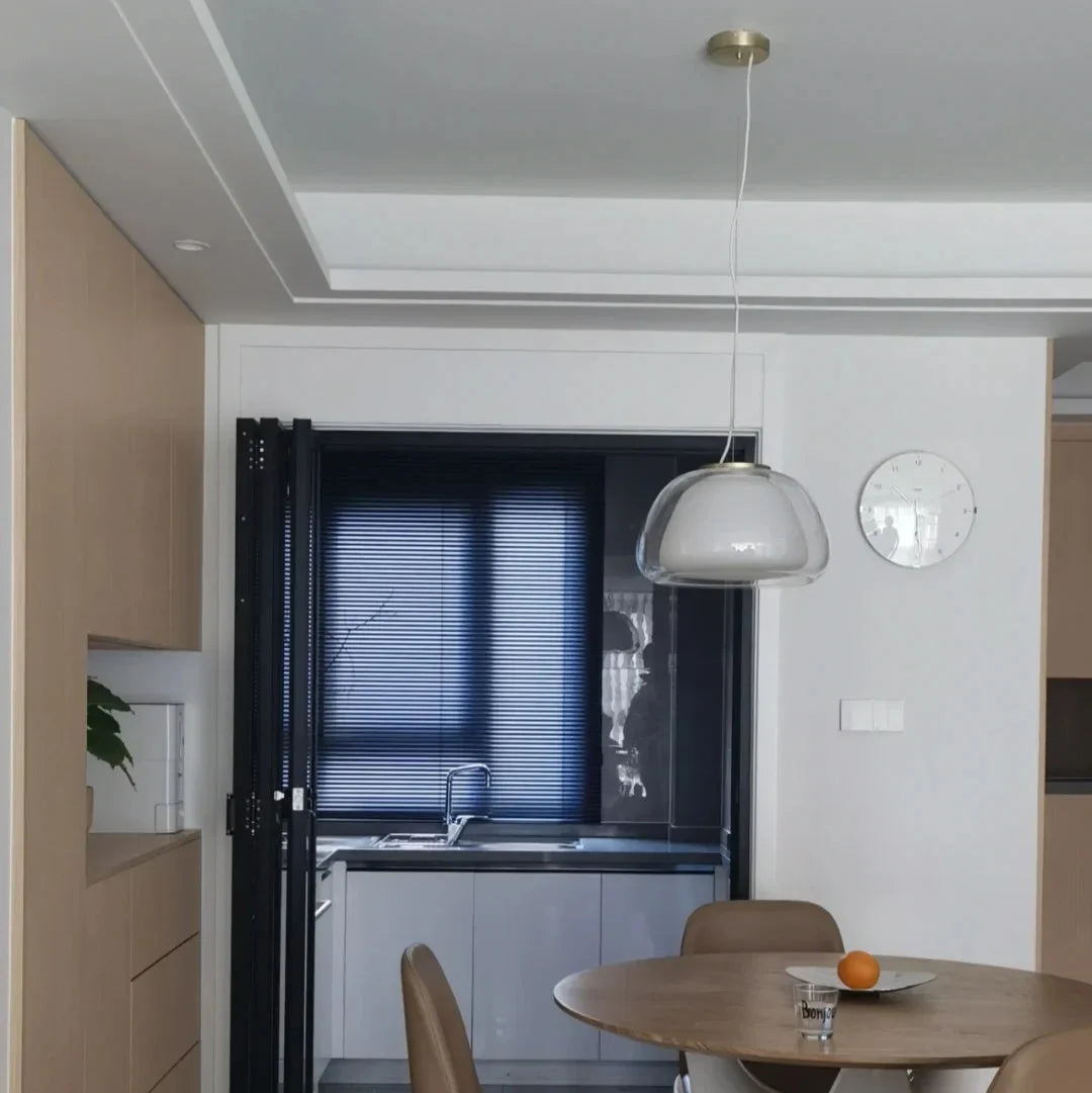 Curved glass pendant light with bell-shaped dome and slim hanging cord