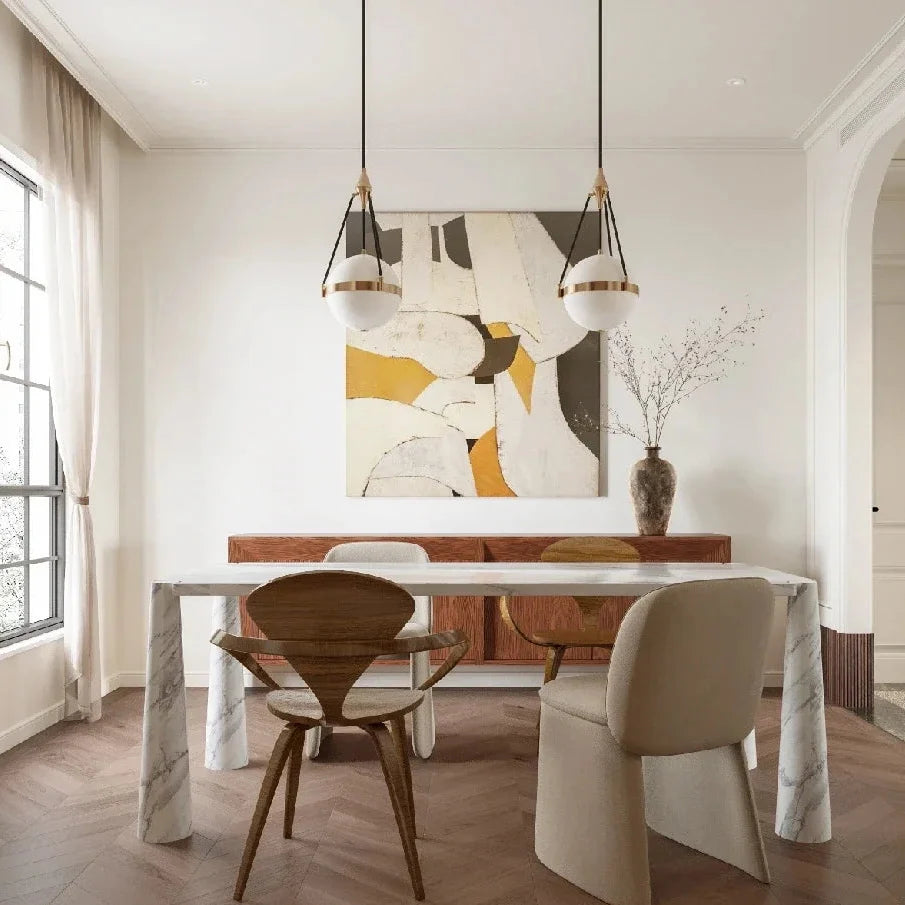 Two globe pendant lights with white glass shades and gold bands on black suspension