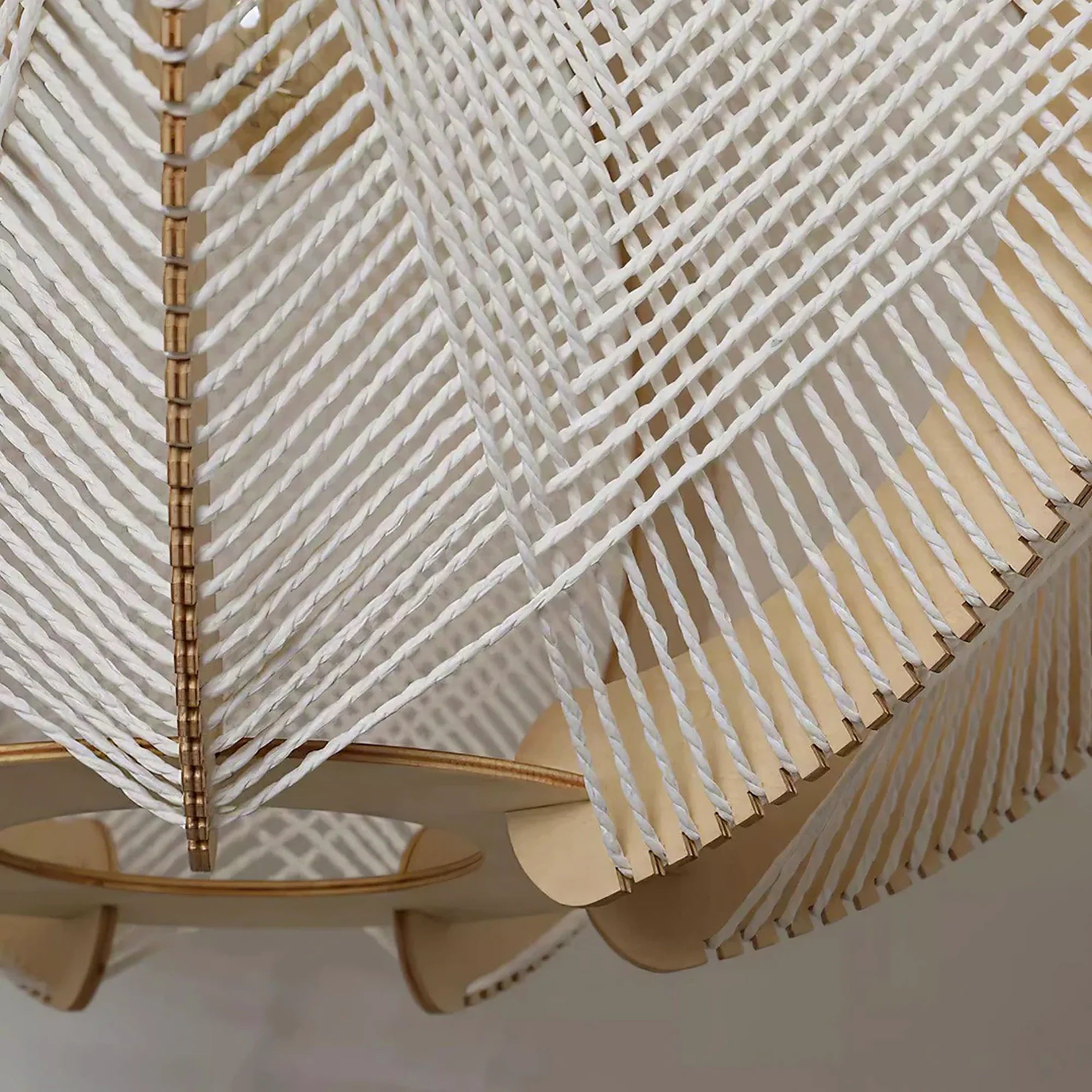 Woven orbit pendant lamp detail with light strands and light wood trim