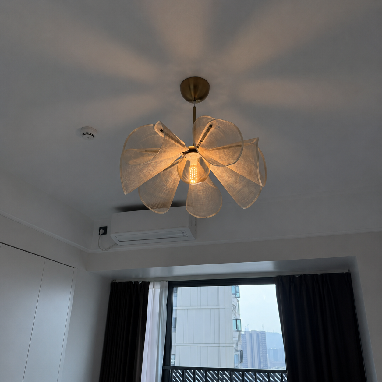 Natural linen ceiling chandelier with six petal shades, brass canopy, warm bulb glow