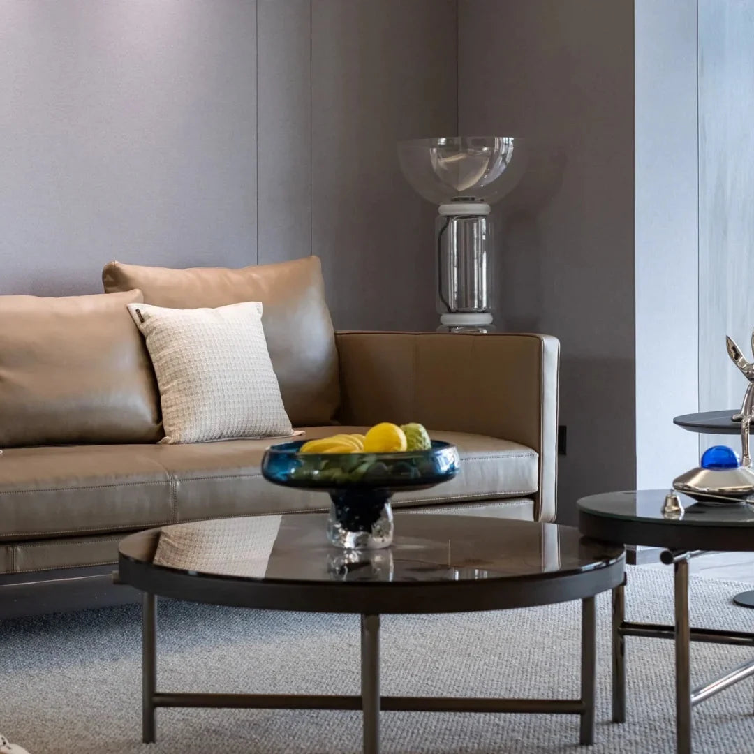 Glass floor lamp with clear bowl top and vertical glass column, black base.