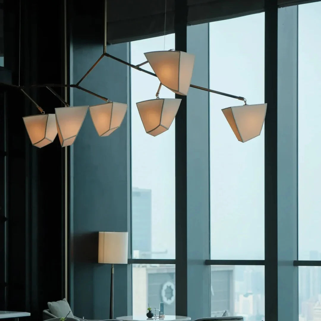 Brass branching chandelier with multiple off-white cone shades suspended from branching frame
