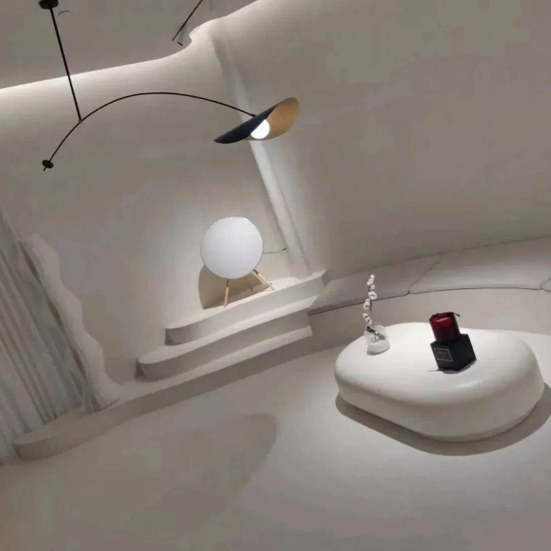 Single-arm pendant light with curved black rod and gold-toned cone shade