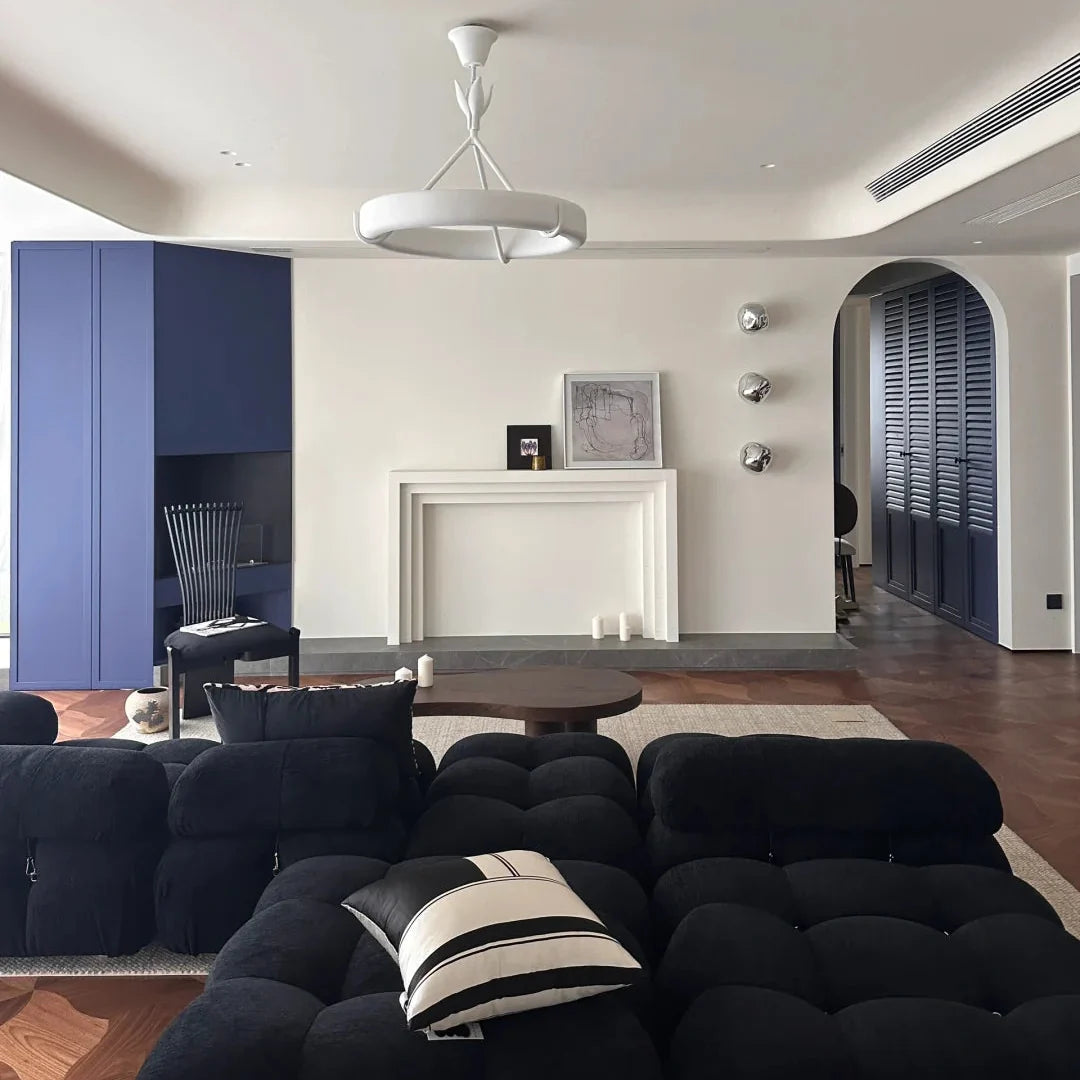 White circular chandelier with branching stem and curved shade ring in a living room ceiling