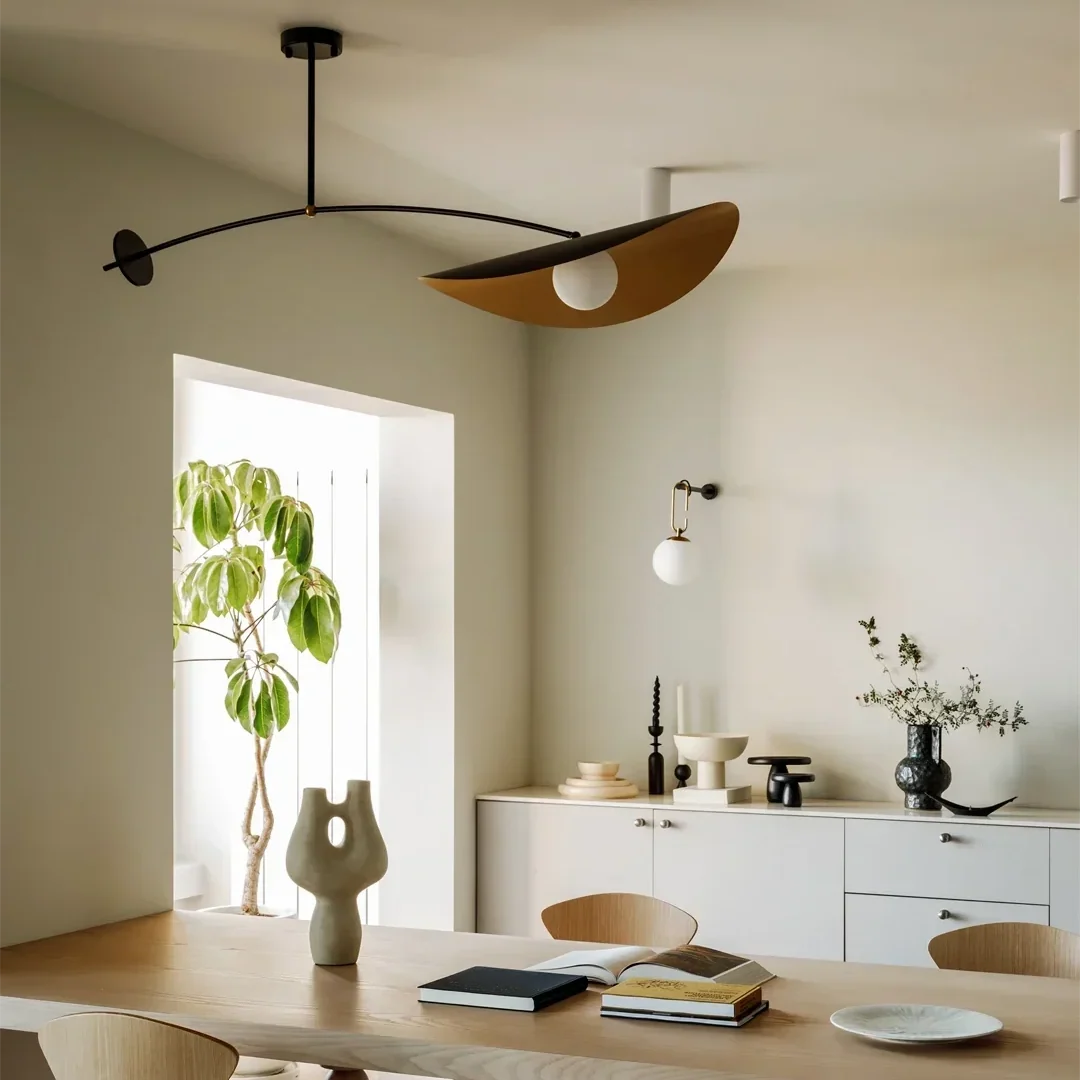 Single-arm pendant light with black curved support and gold inner shade, ceiling flush mount