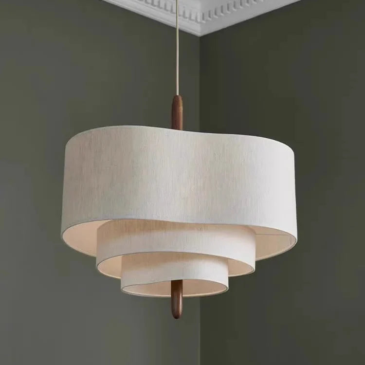 Beige linen pendant light with layered drum shades and dark wood top