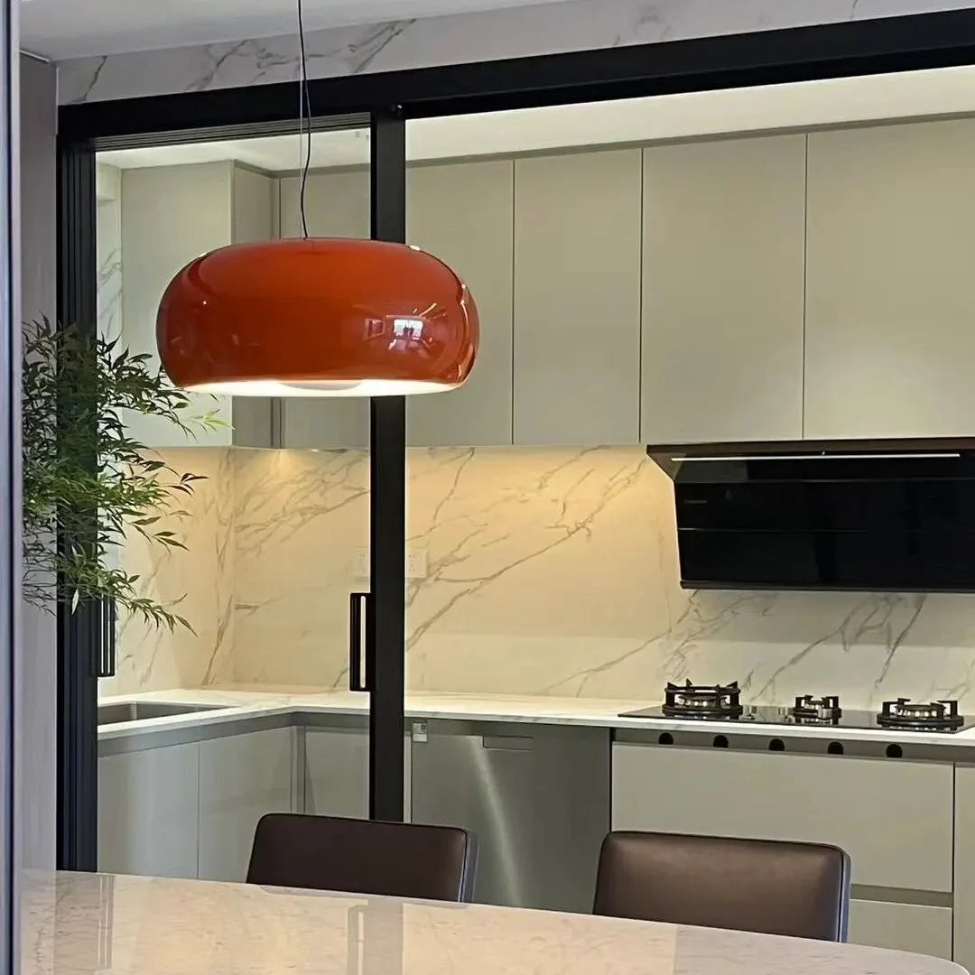 Amber blown glass pendant light with glossy dome shade and black ceiling cord.