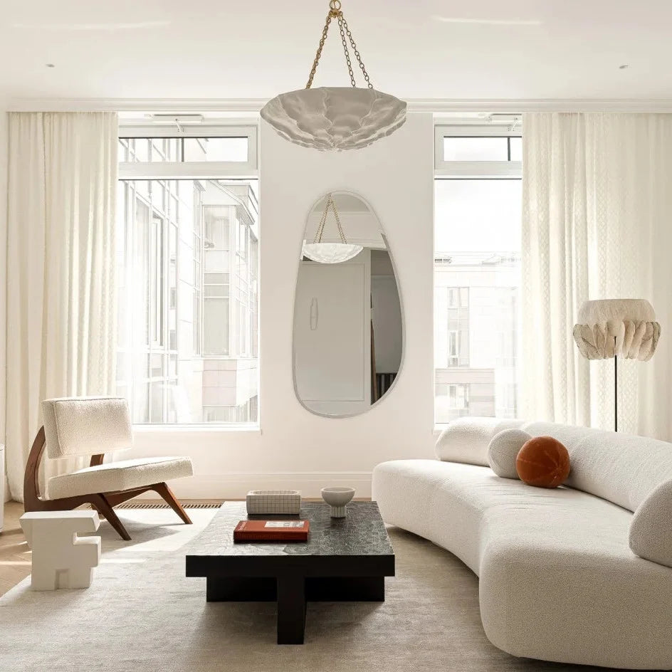 Petal chandelier with white shade and gold-tone chain hanging over living room