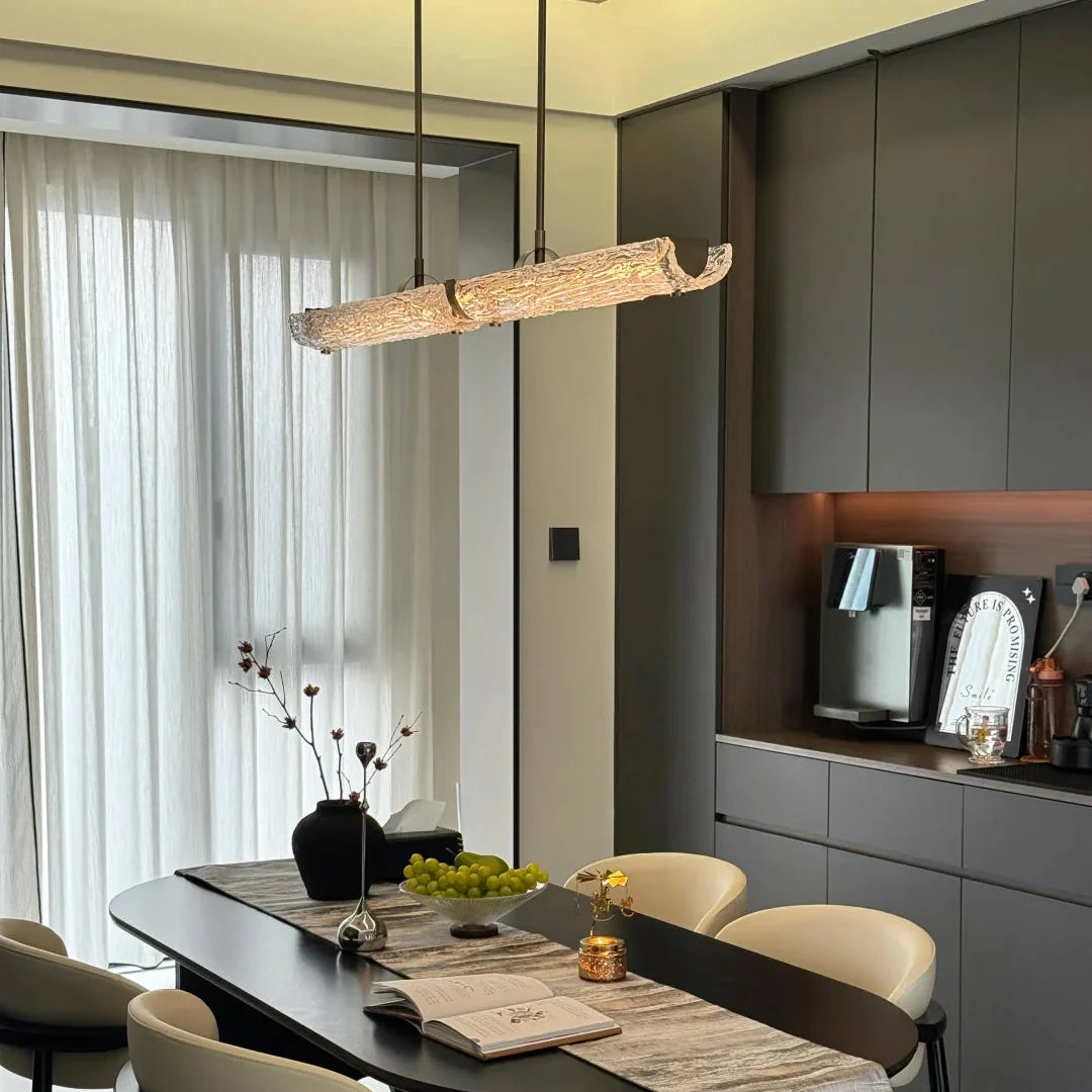 Long linear pendant light with frosted textured glass bar and chrome end brackets