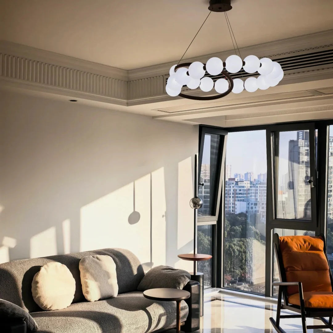Pearl chandelier with a spiral row of white globe shades and circular metal frame