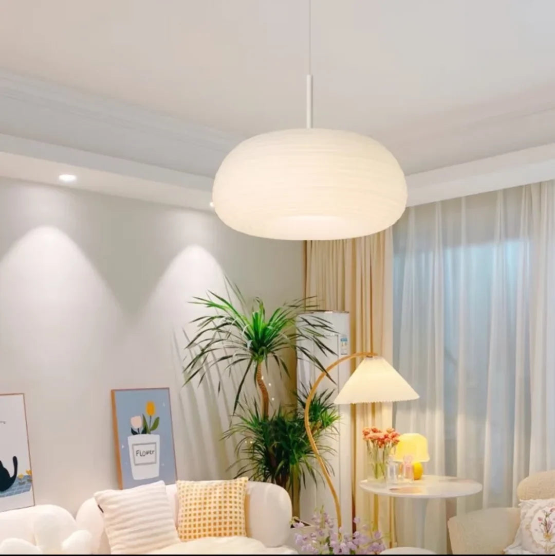 Cream-white ribbed pendant light with round shade above a living area