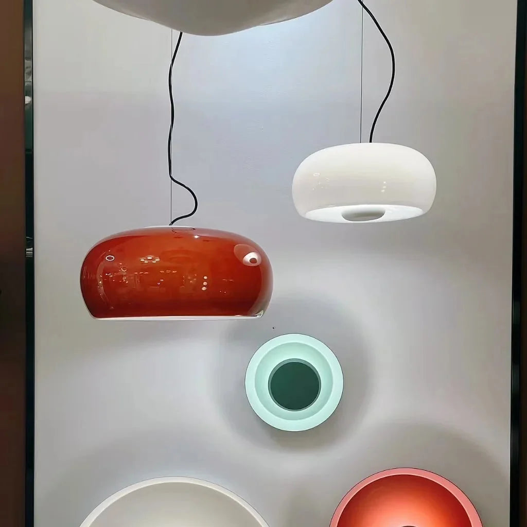Amber blown glass pendant lamp with glossy rounded dome shade and black hanging cord.