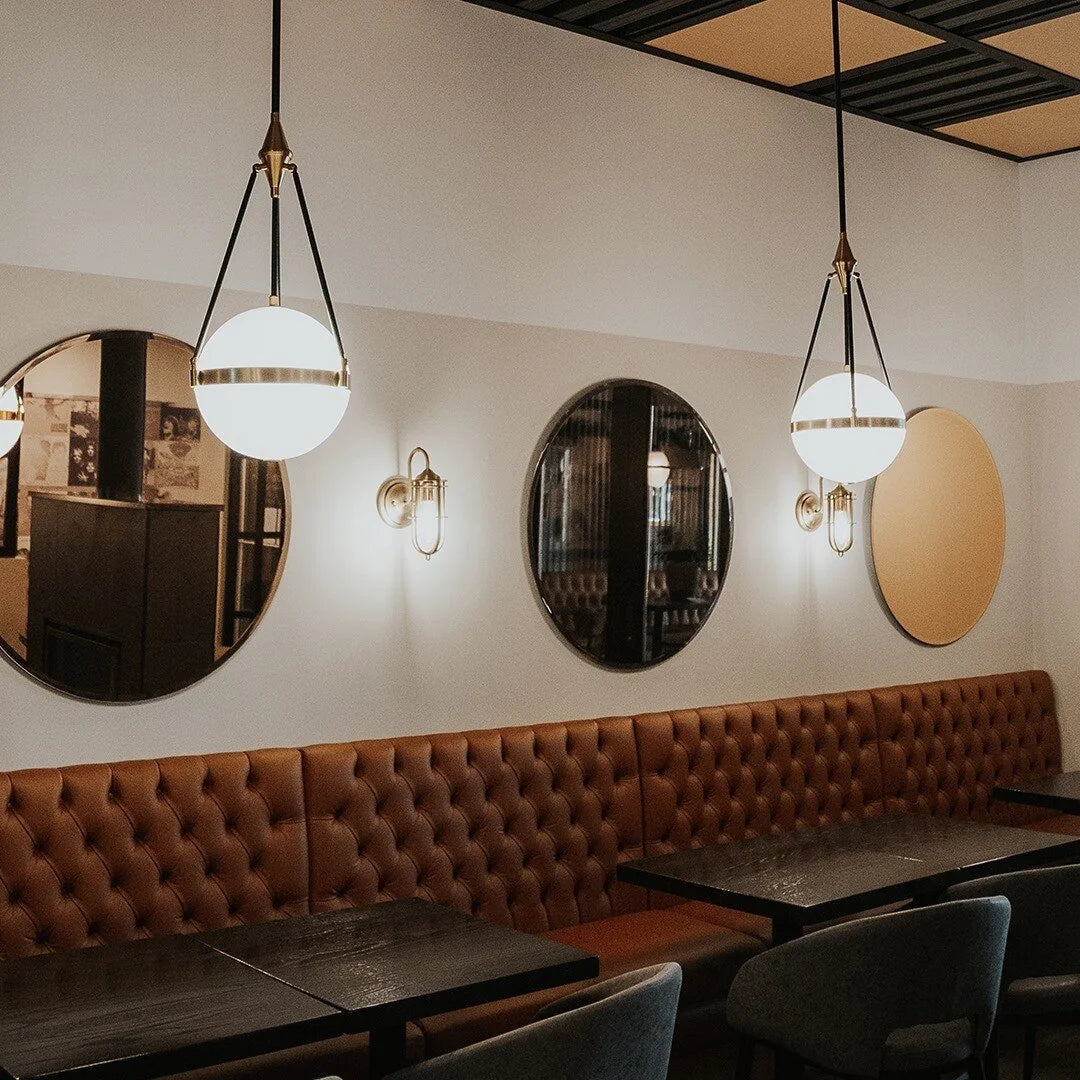 Glass globe pendant light with round white shades and slender black hanging rods
