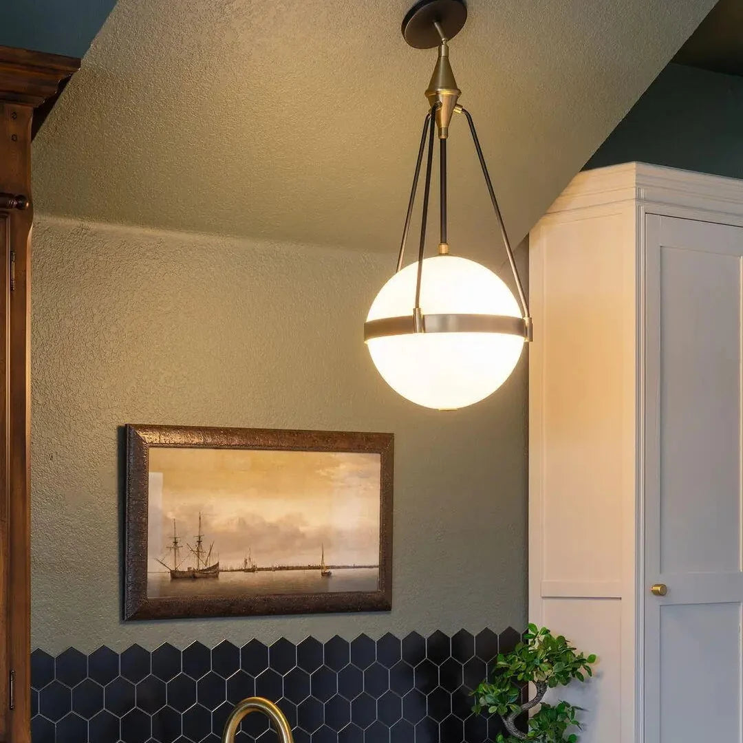 Globe pendant light with white glass globe and gold metal frame with black rods