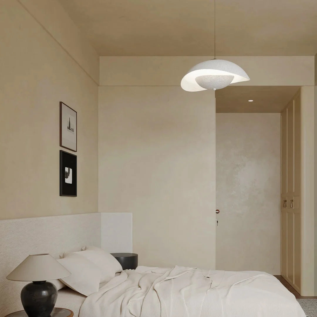 White aluminum dome pendant light with wave cutout and warm downward glow