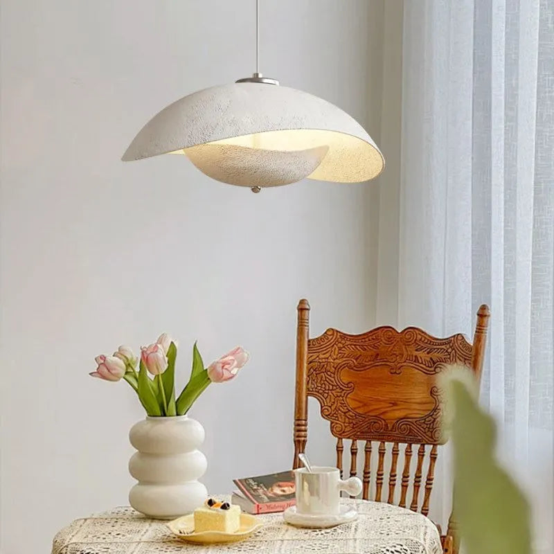 Gray aluminum wave pendant light with curved shade emitting warm light