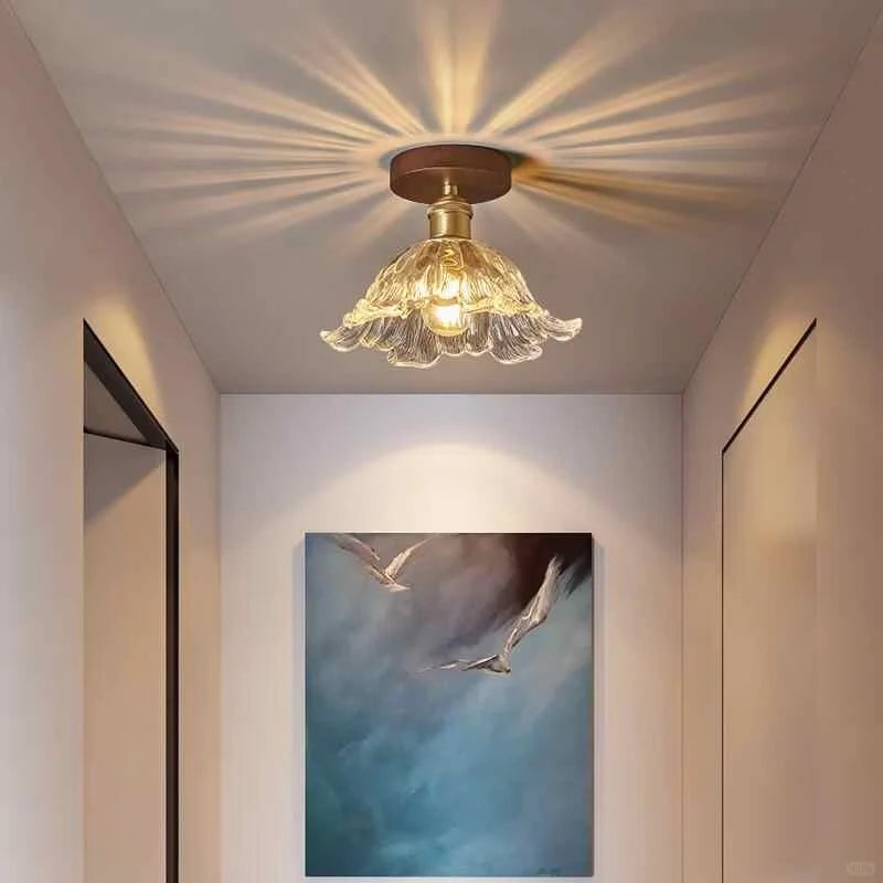 Semi-flush ceiling light with gold finish and clear petal-style glass shade
