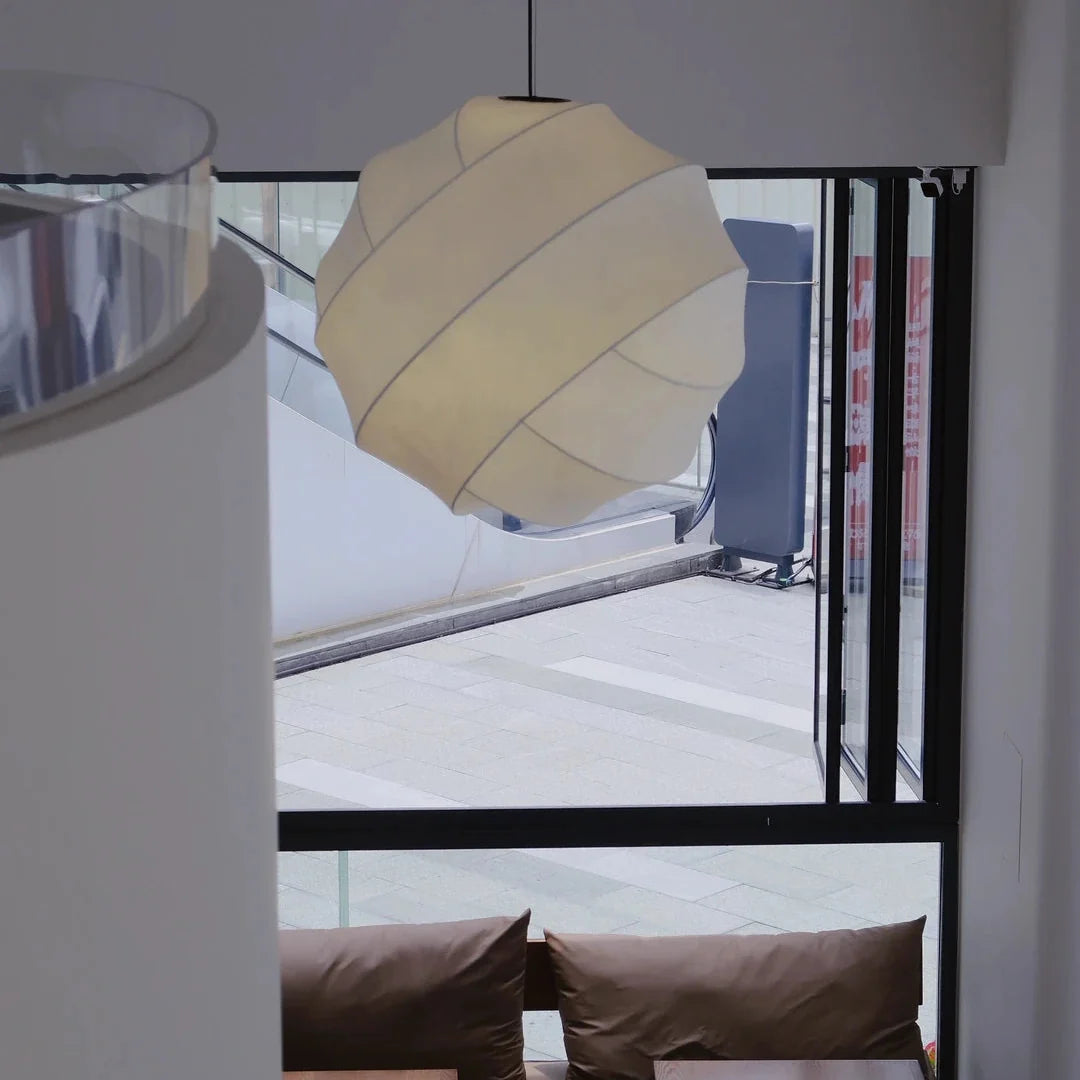 Luma silk pendant light with cream-beige pleated fabric shade near a window