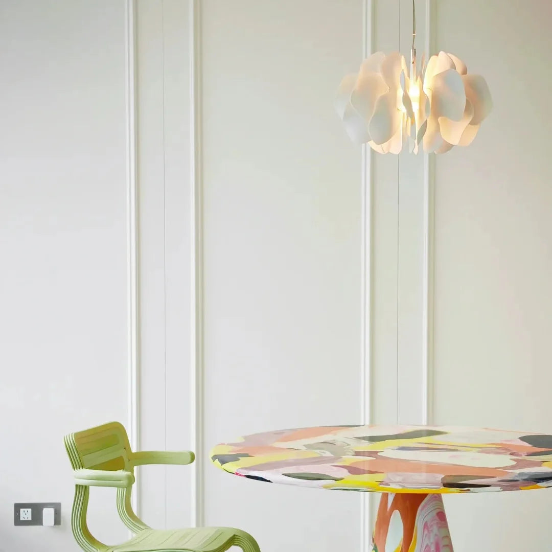 Ceramic petal chandelier pendant with glowing white petal shades against a light ceiling