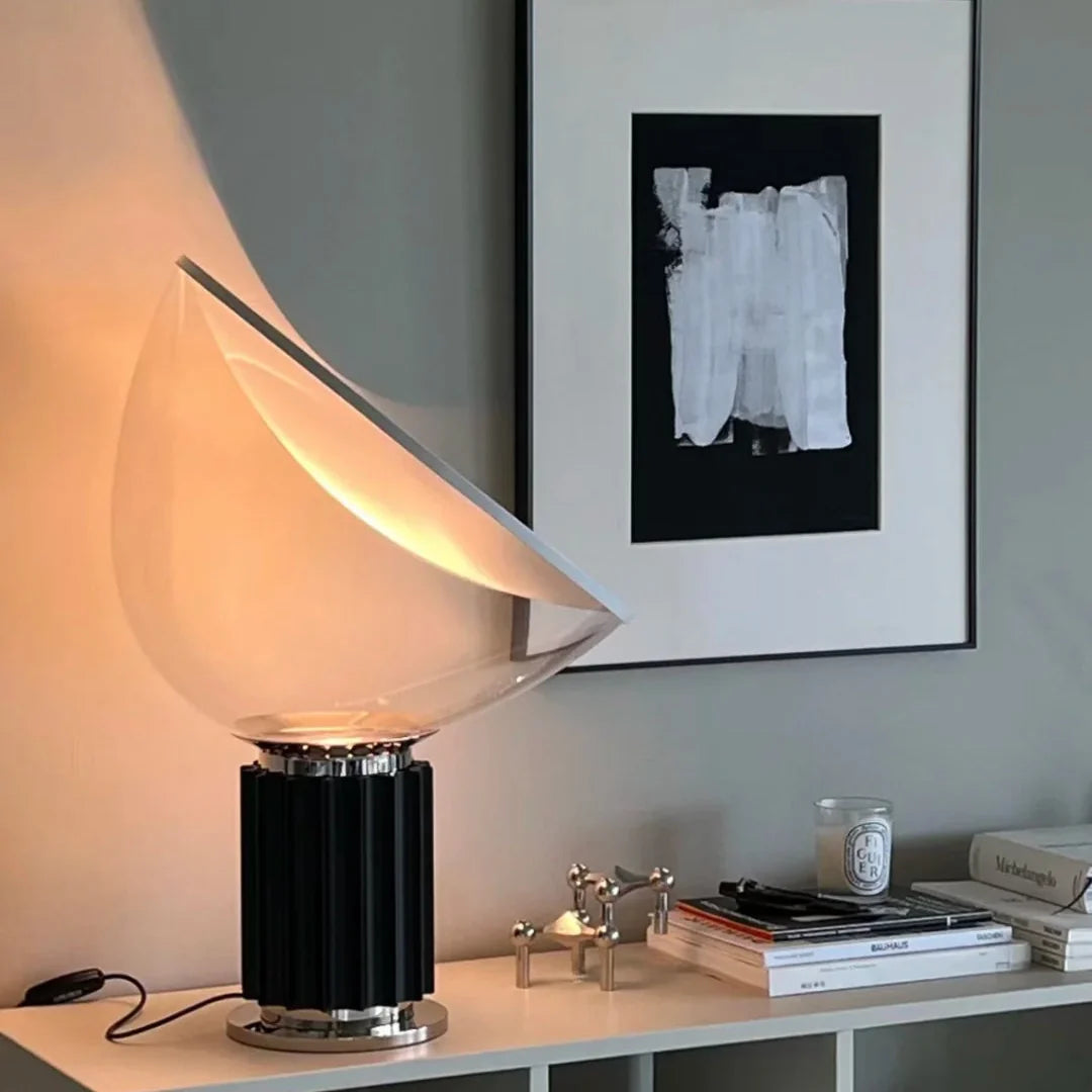 Dome glass saucer table lamp with clear dome shade and black ribbed base, warm lit
