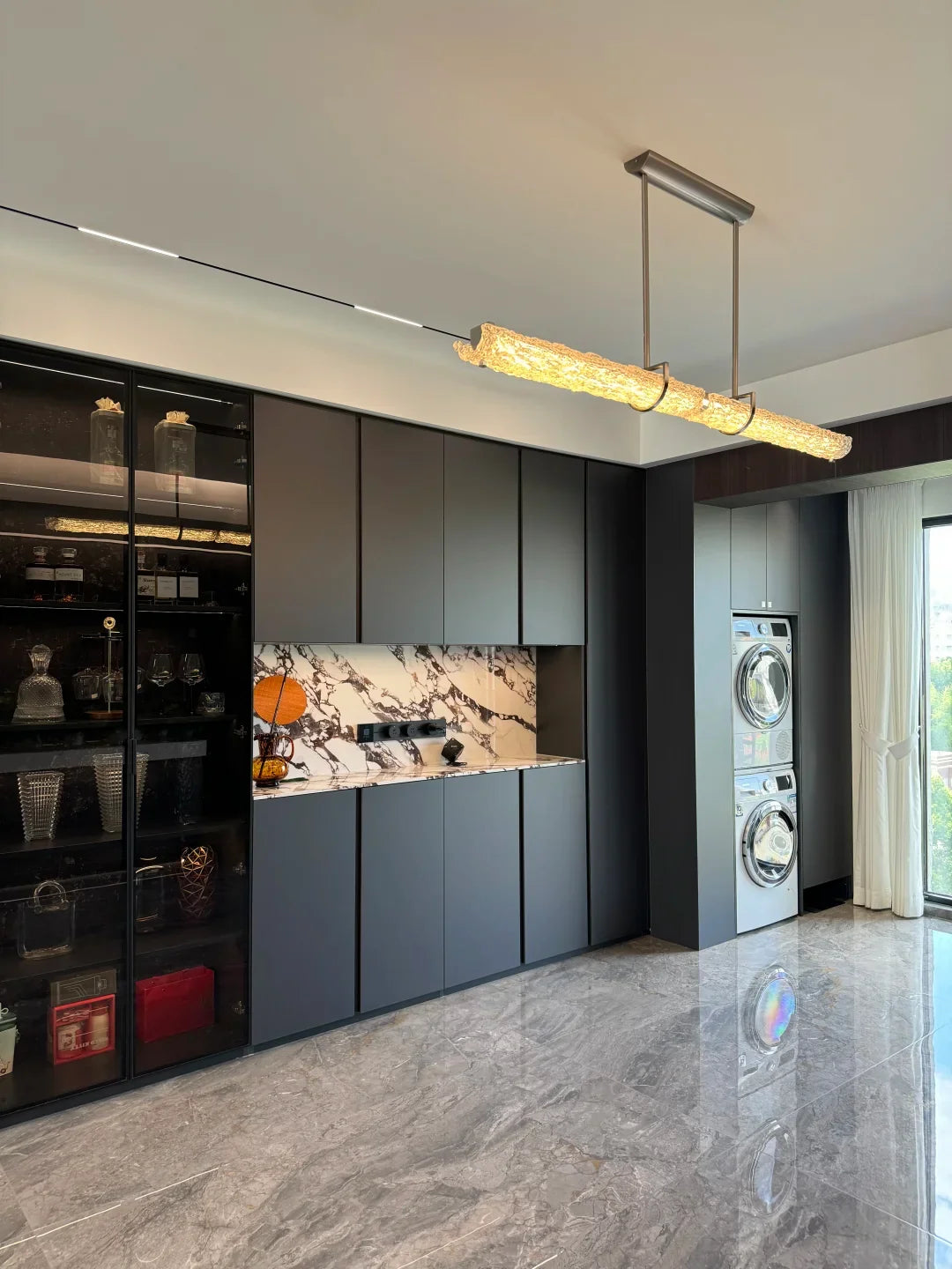 Linear glass pendant light with textured tube, chrome ceiling mount, and two rods