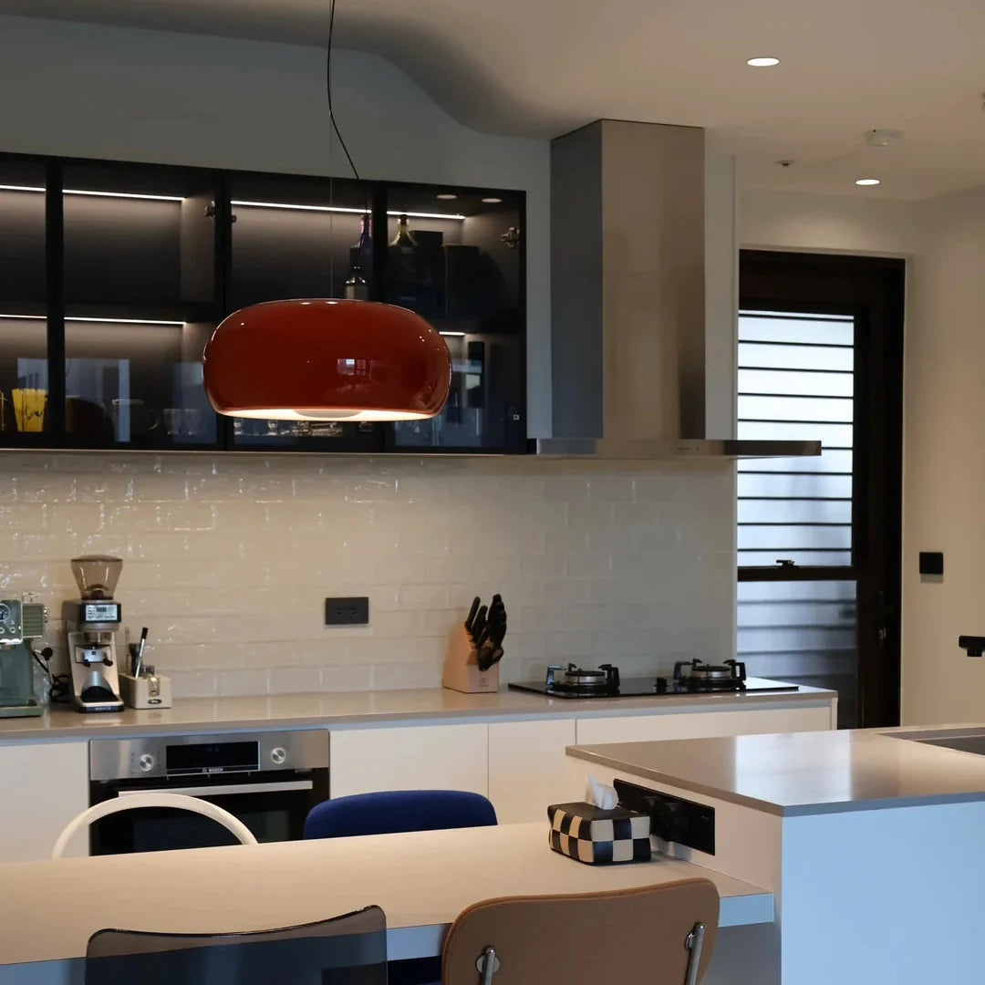 Amber blown glass pendant light with rounded amber glass dome shade and black cord.