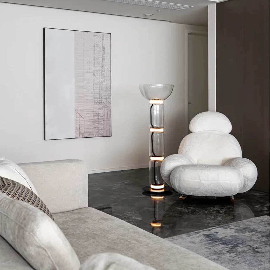 Glass floor lamp with stacked clear glass chambers and black round base.