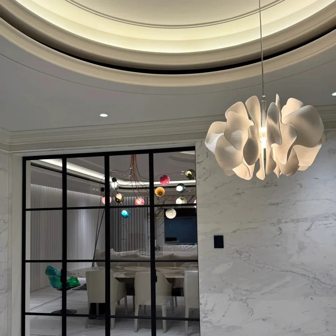 Ceramic petal chandelier on ceiling with layered white petal shades and warm light