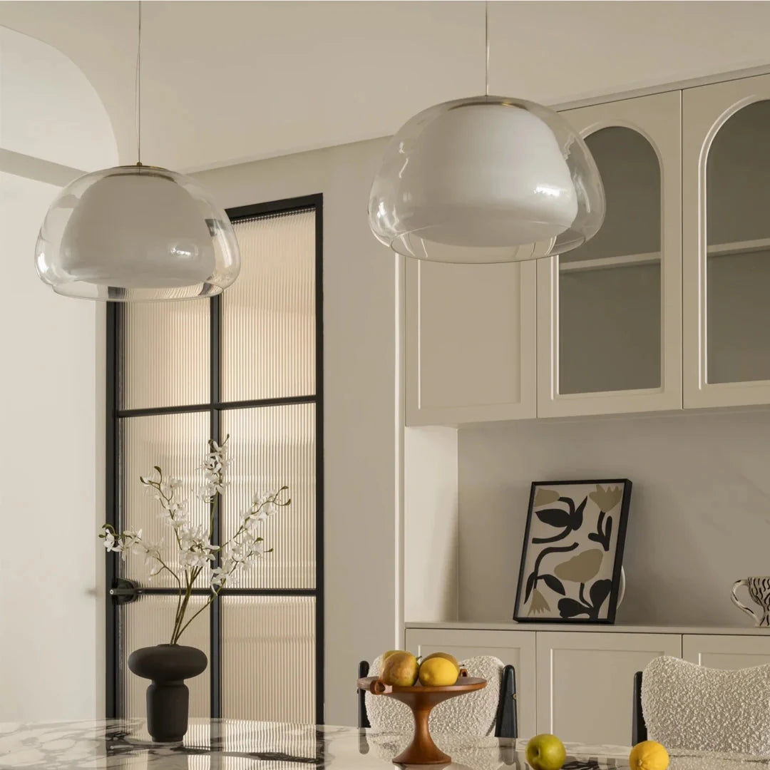 Curved glass pendant light with rounded dome shade and gold canopy
