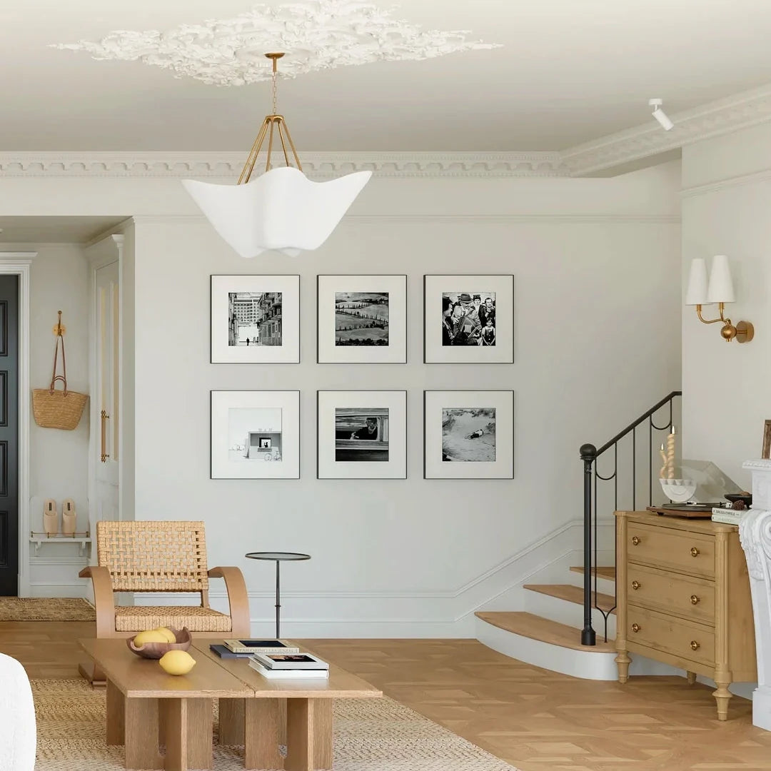 Chalk white plaster chandelier with scalloped flower-like shade centered above seating
