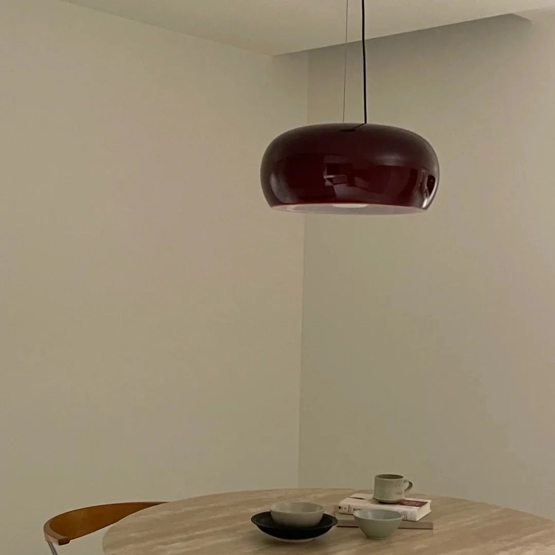 Amber blown glass pendant light with curved dark-brown dome shade and black cord.