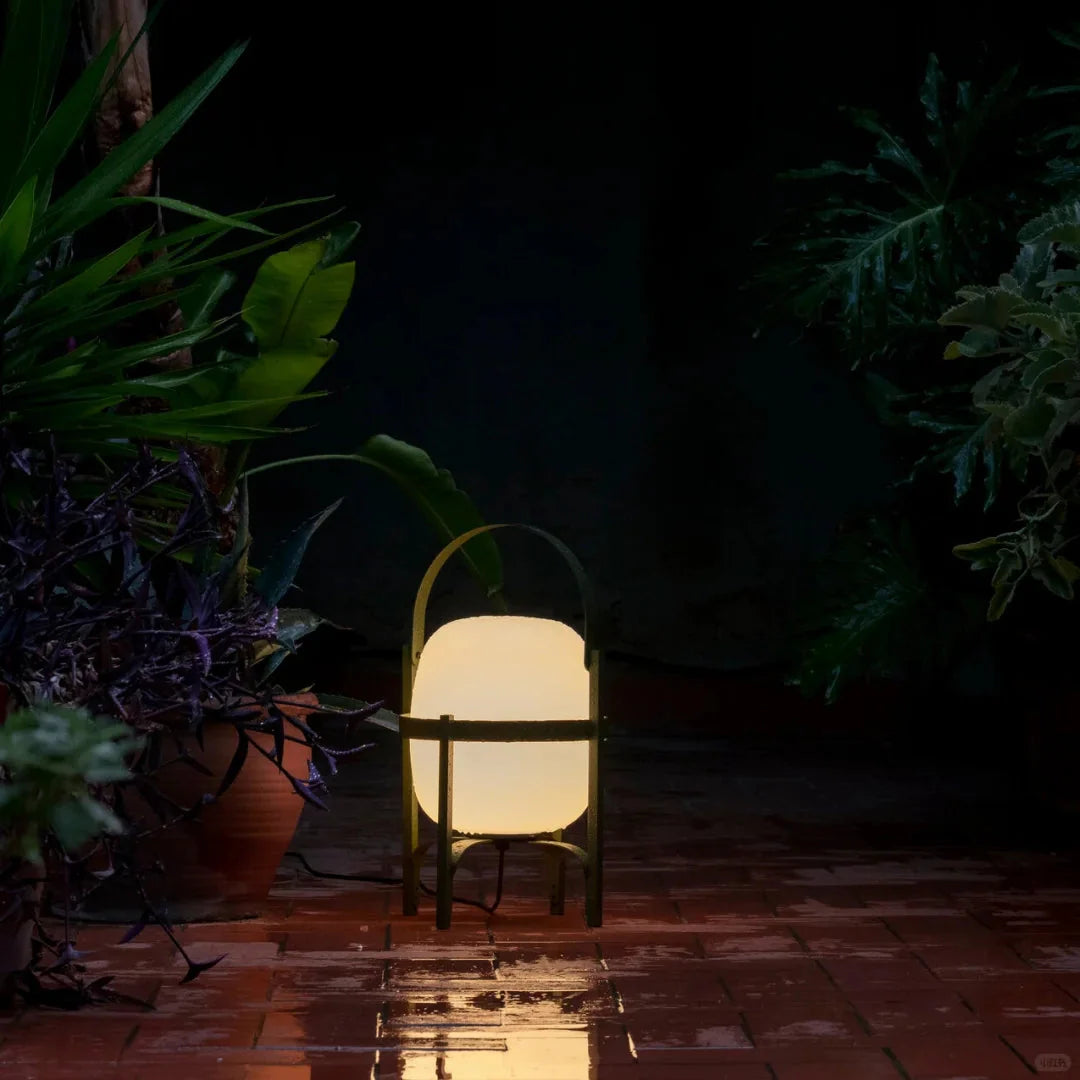Outdoor table lamp with warm glow frosted globe shade and dark frame