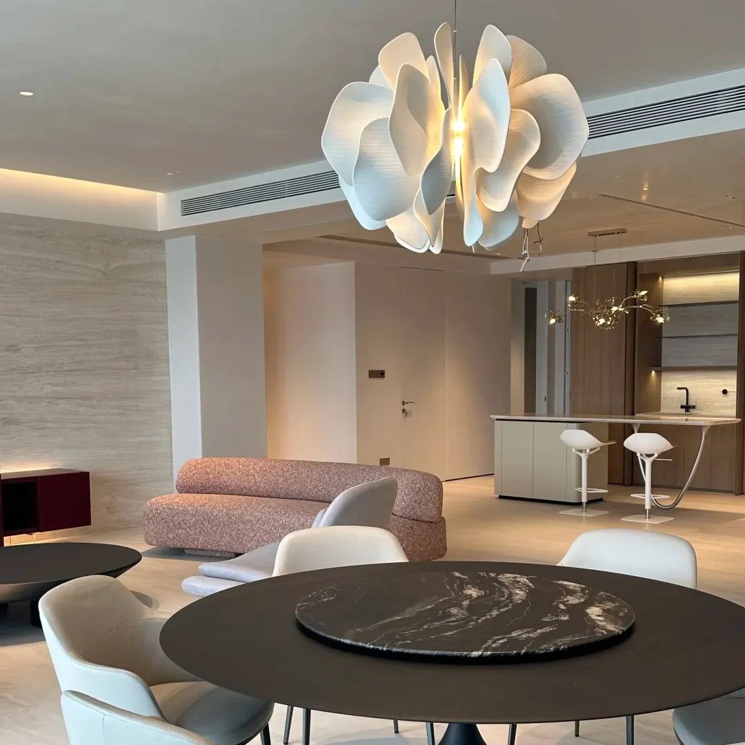 Ceramic petal chandelier with layered white petal shades, glowing in the center