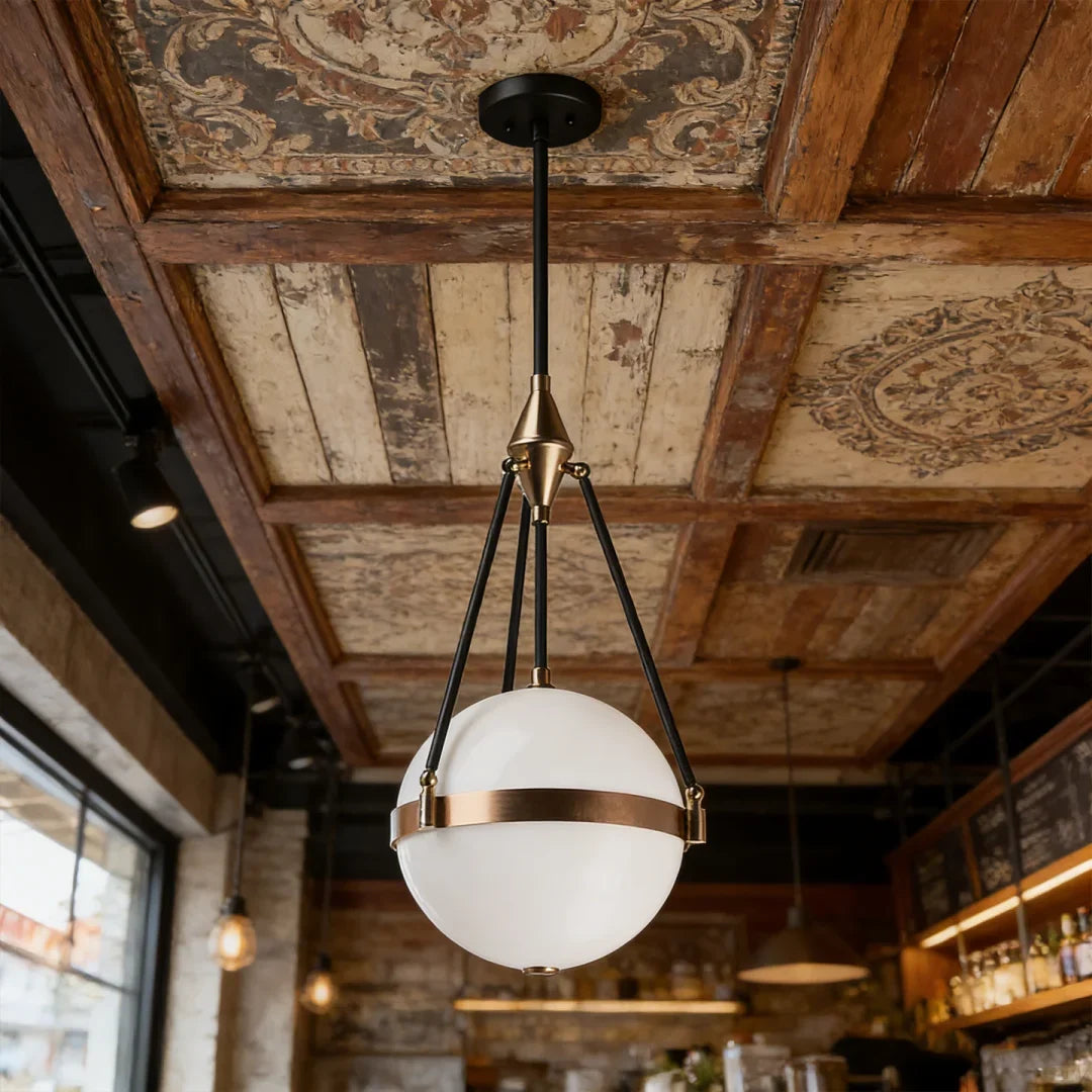 Globe pendant light with white glass diffuser, black tripod frame, and gold band