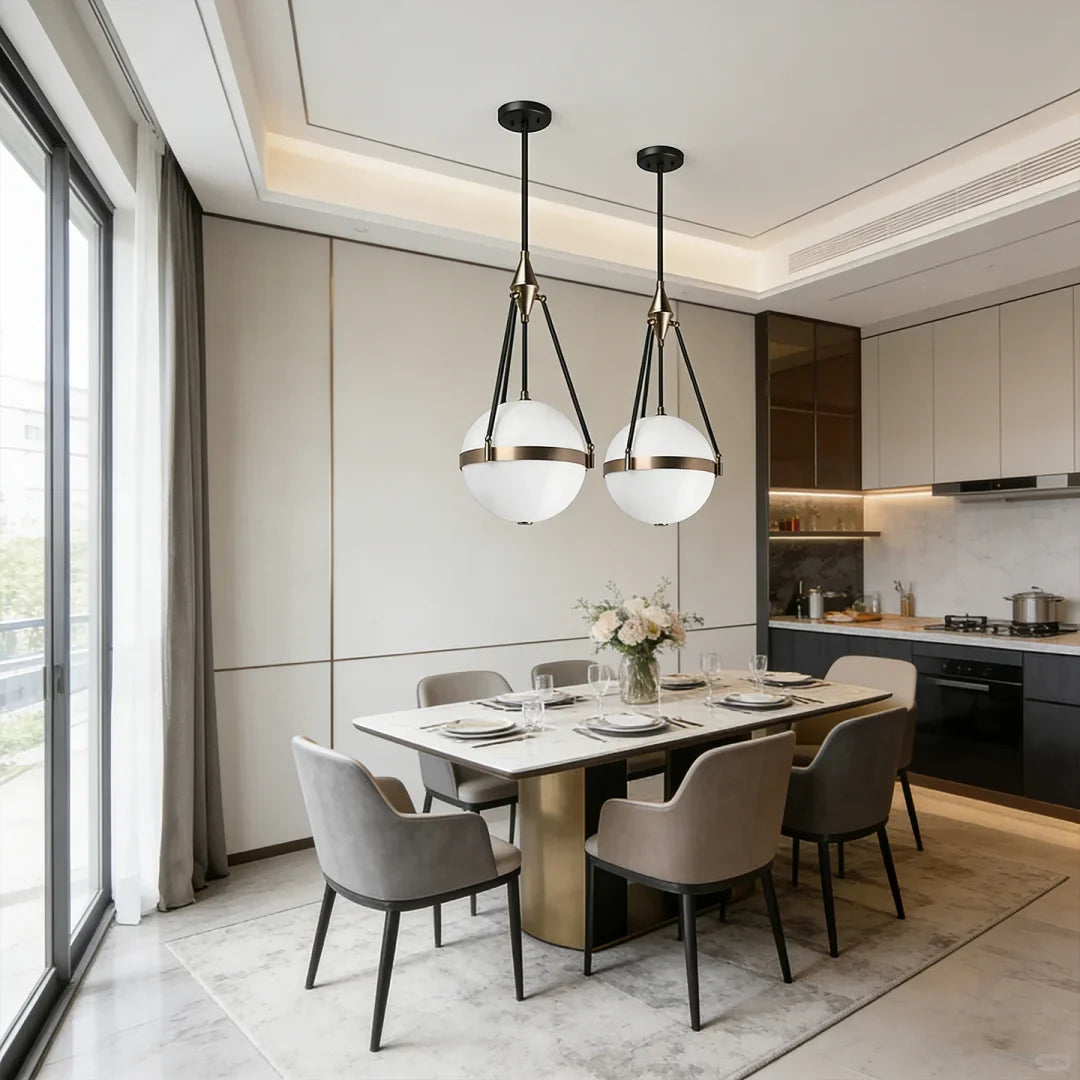 Two globe pendant lights with white glass shades, black rods, and gold metal tops
