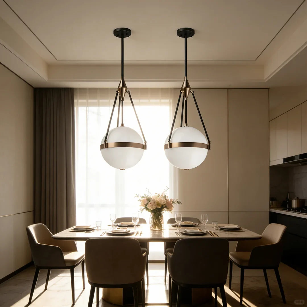 Pair of globe pendant lights with white glass spheres and gold accents on black frames