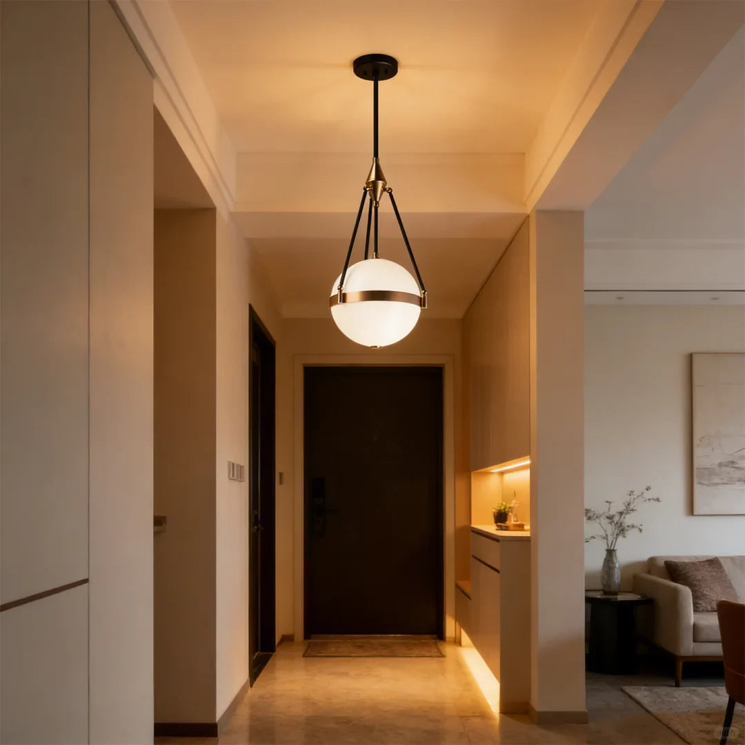 Globe pendant light with white glass sphere, gold detailing, and black ceiling mount