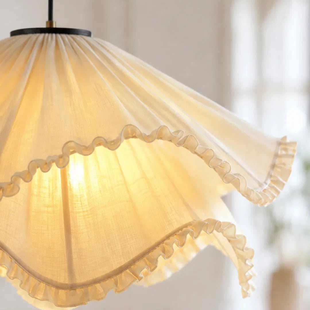 Close-up of cream pleated fabric pendant light with ruffled trim around the shade