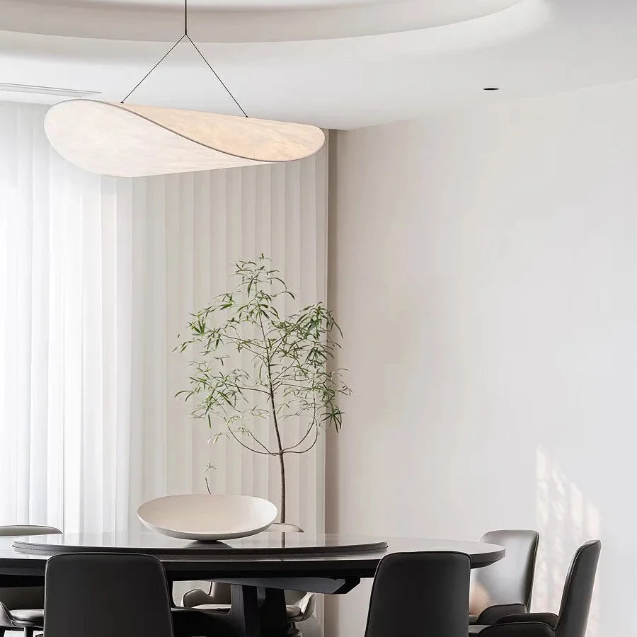 Beige oval paper pendant light with thin black cord, modern ceiling fixture.