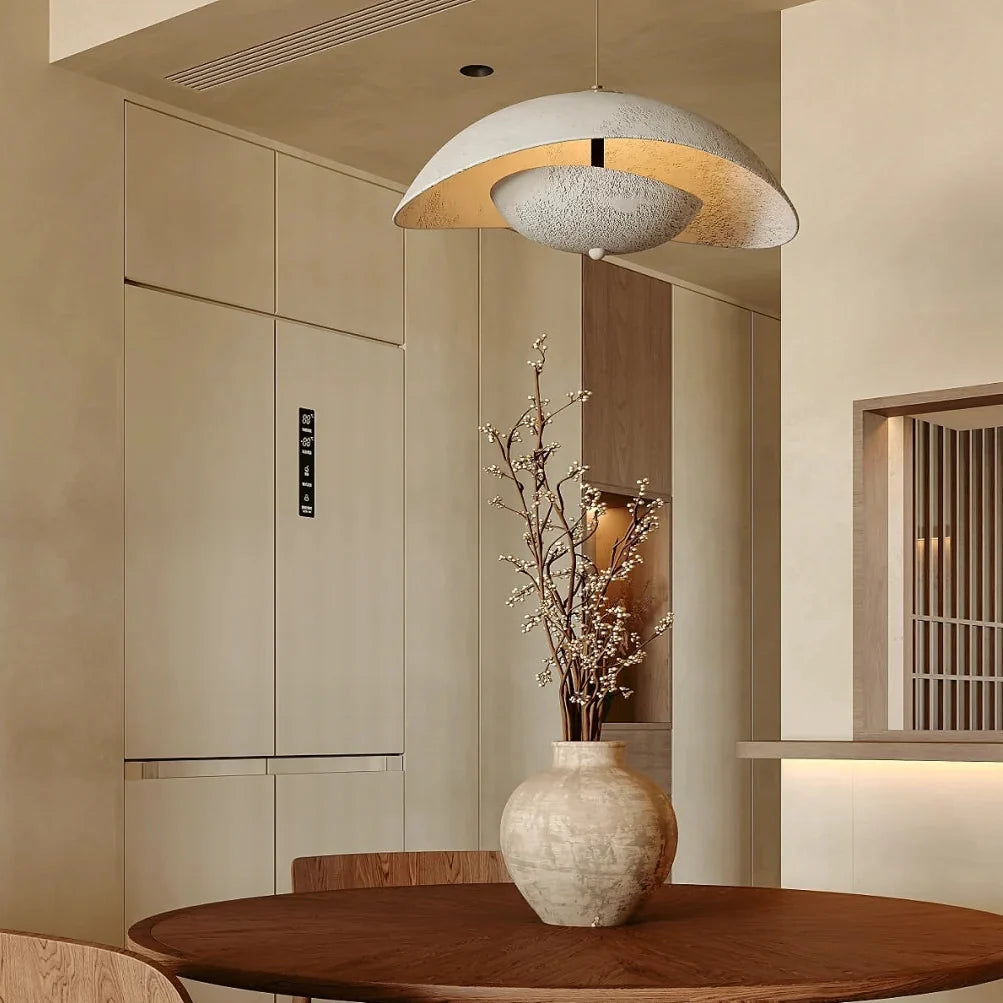 Textured gray aluminum wave pendant light hanging above dining area