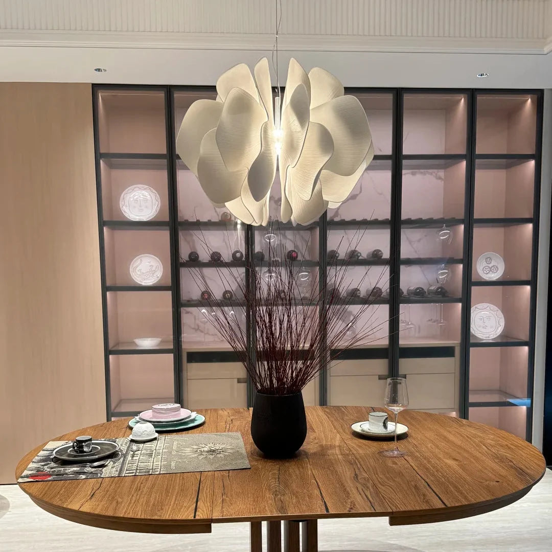 Ceramic petal chandelier above a round table with warm-lit white petal shades