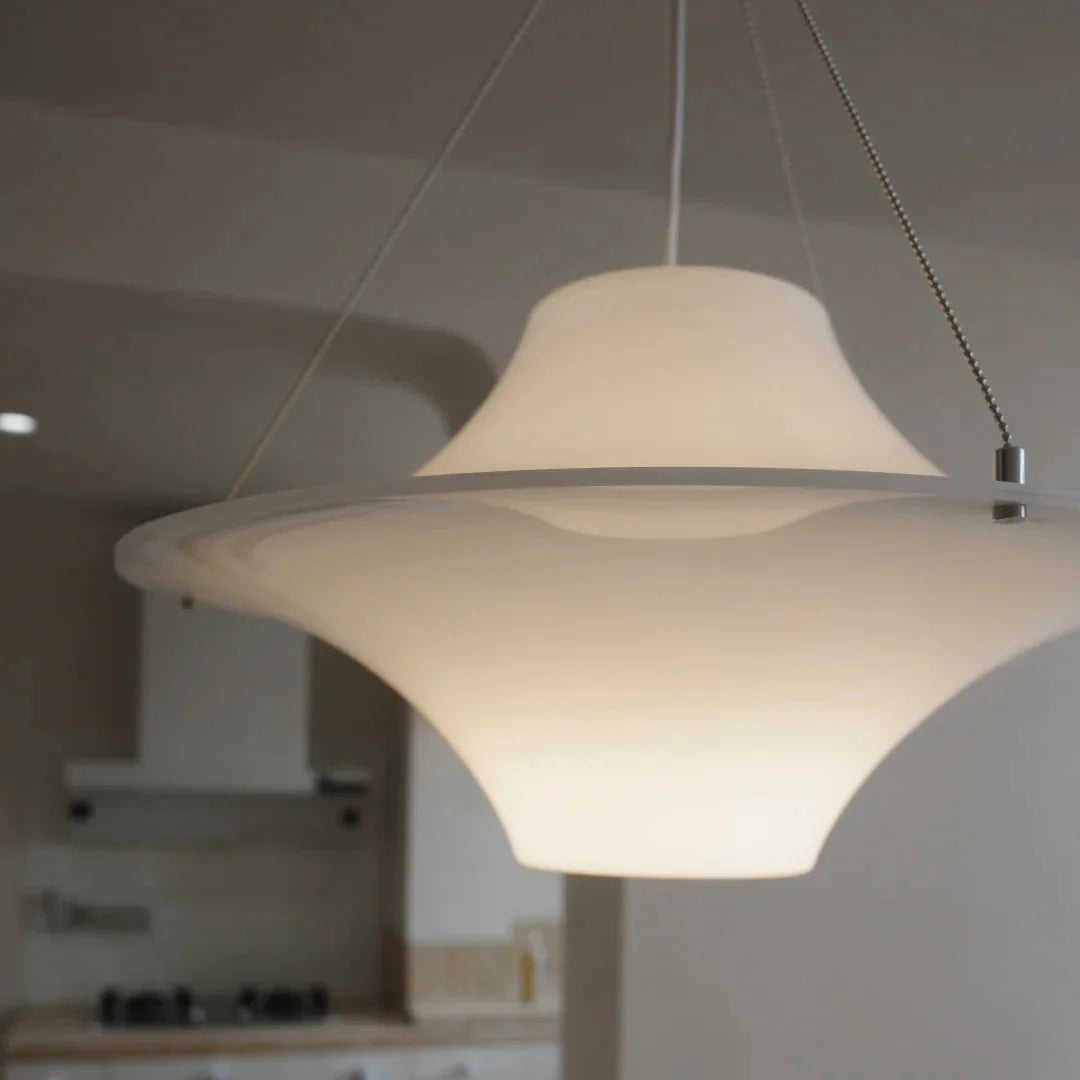 Close-up of white star-shaped disc pendant light with hanging cord