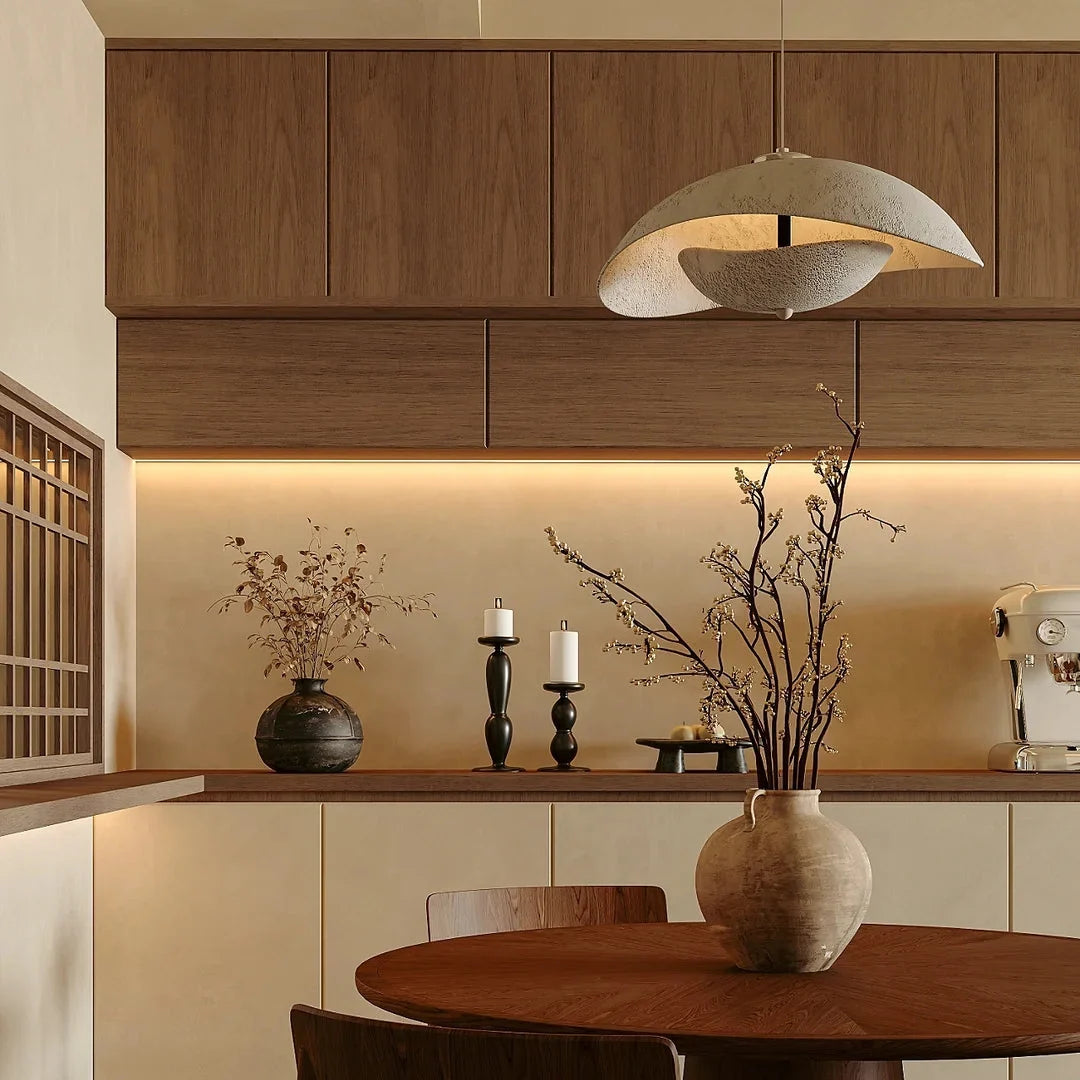 Gray aluminum wave pendant light suspended over kitchen island with warm light