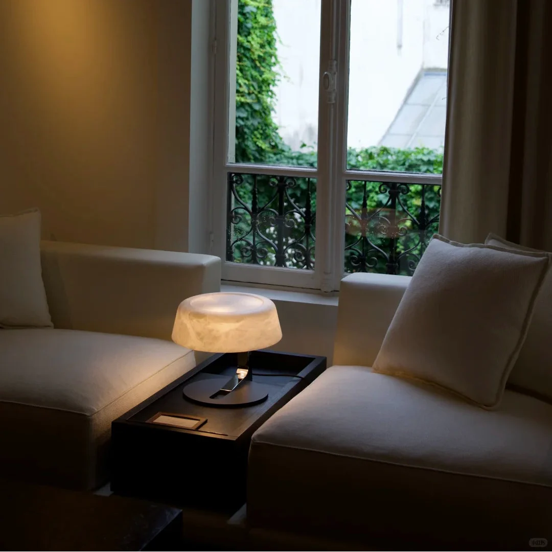Luma Alabaster table lamp with glowing white dome shade on black round base