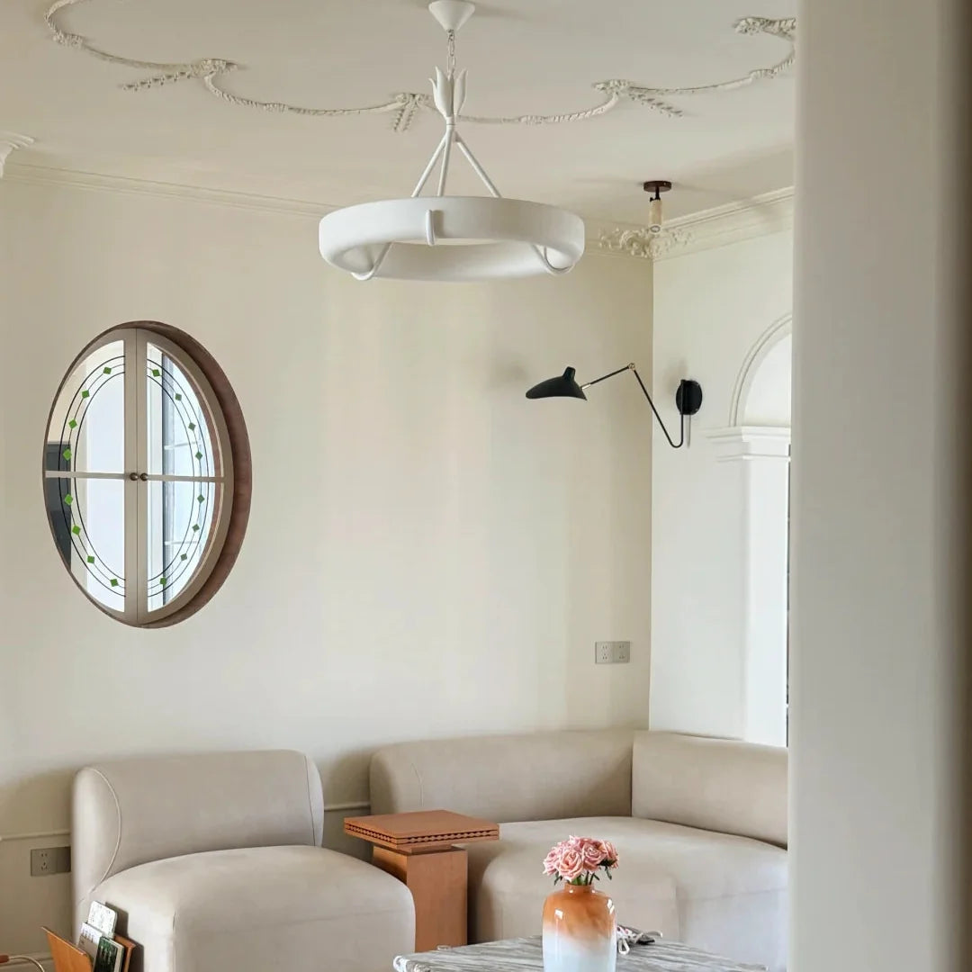 White circular ceiling chandelier with sculpted stem and round shade, centered in room