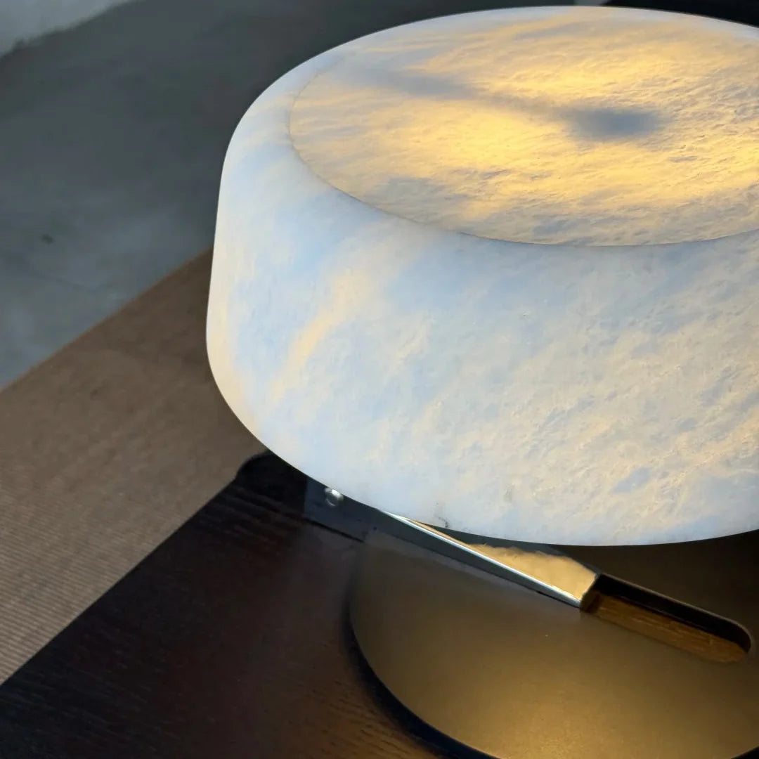 Alabaster table lamp with round opal shade and brushed metal base with black platform