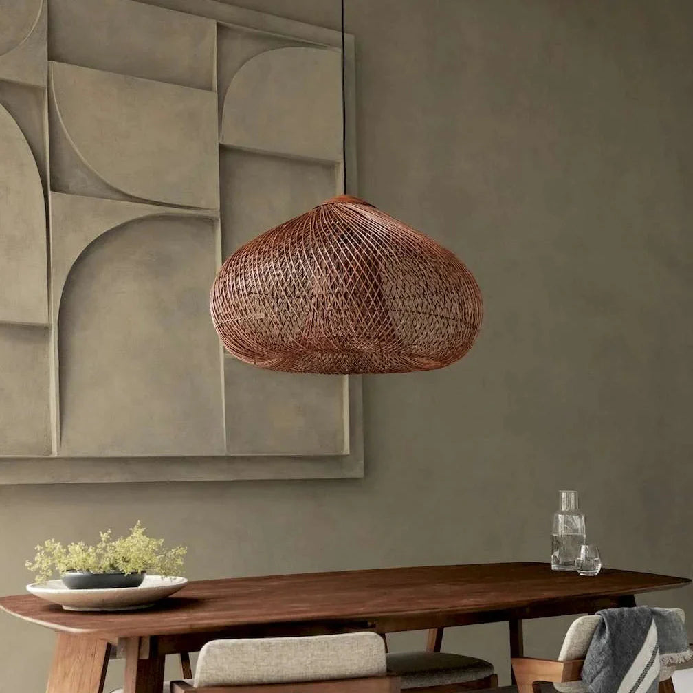 Rust-red rattan pendant light with woven dome shade and black ceiling mount.