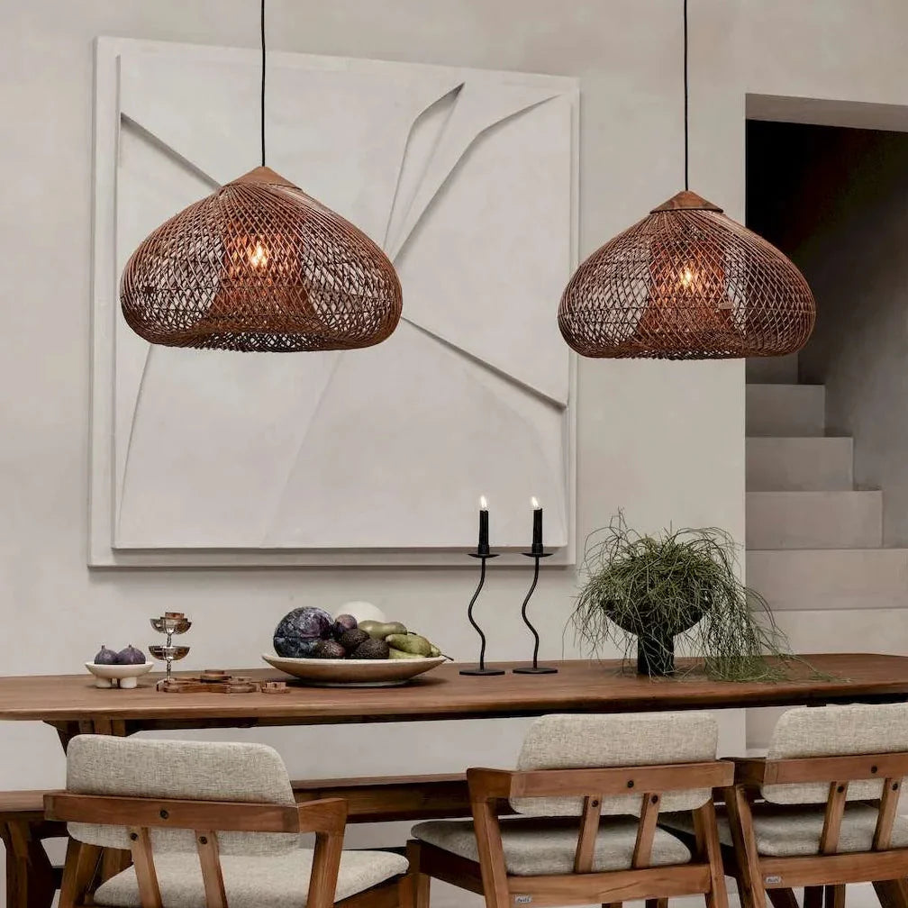 Two brown rattan pendant lights with dome lattice shades above dining table.