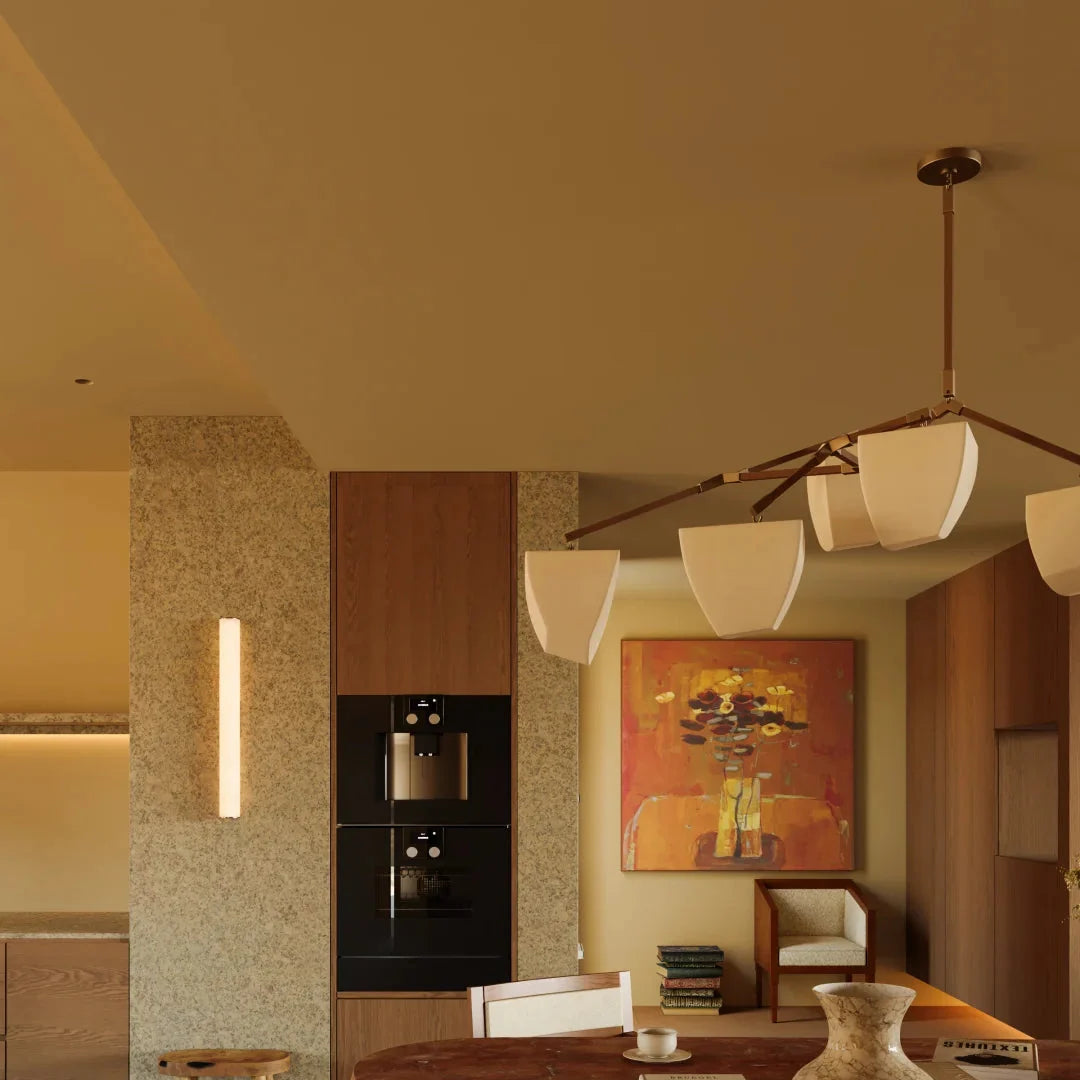 Brass branching chandelier with frosted white shades and brass arms in lounge